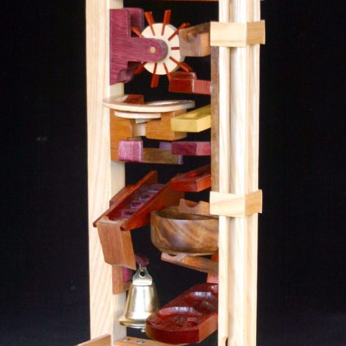 Fun action toy using marbles to drop, spin, ring a bell and zig zag through the obstacle course